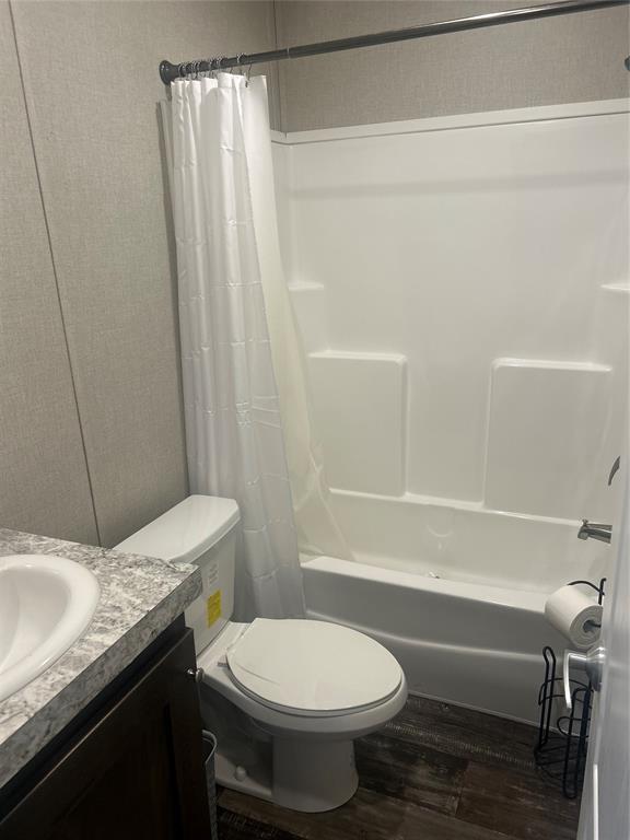 4341 Paradise Rd, Kingston, OK 73429 - full bath with wood finished floors, toilet, shower / tub combo with curtain, and vanity