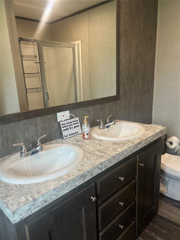 4341 Paradise Rd, Kingston, OK 73429 - full bathroom with double vanity, toilet, a stall shower, and wood finished floors