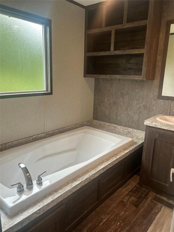 4341 Paradise Rd, Kingston, OK 73429 - full bath featuring vanity, a garden tub, and wood finished floors