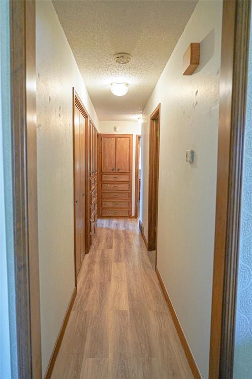 2313 SW 91st St, Oklahoma City, OK 73159 - corridor featuring a textured ceiling, light wood-style flooring, and baseboards