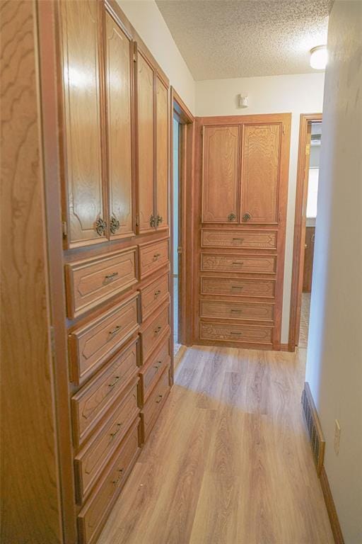 2313 SW 91st St, Oklahoma City, OK 73159 - hall with light wood-style flooring, a textured ceiling, and baseboards