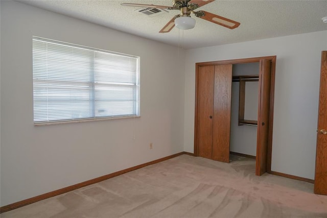 2313 SW 91st St, Oklahoma City, OK 73159 - unfurnished bedroom with a closet, light colored carpet, baseboards, ceiling fan, and a textured ceiling