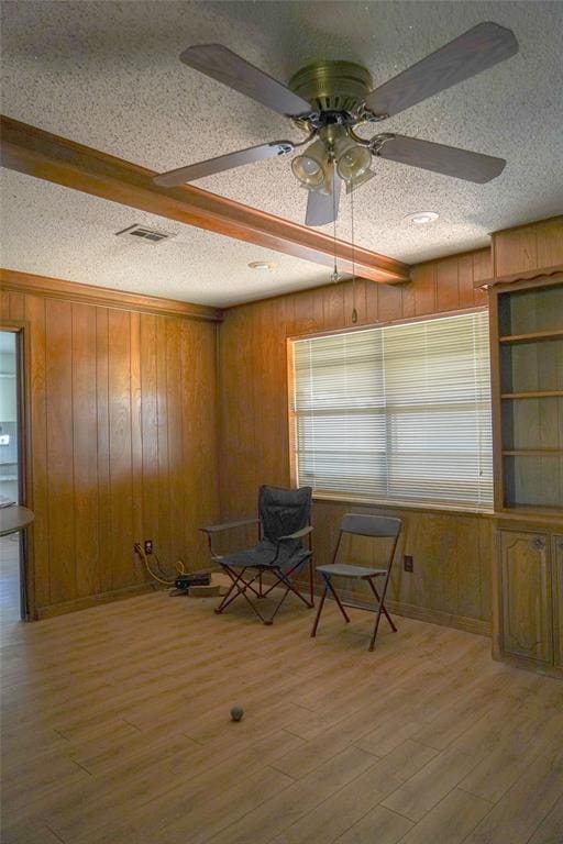 2313 SW 91st St, Oklahoma City, OK 73159 - living area featuring a textured ceiling, wooden walls, a ceiling fan, and wood finished floors
