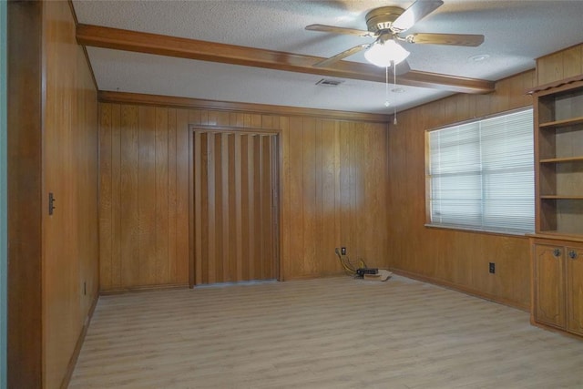 2313 SW 91st St, Oklahoma City, OK 73159 - unfurnished room featuring beam ceiling, light wood-type flooring, a ceiling fan, wooden walls, and a textured ceiling