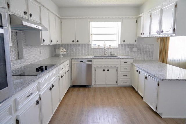 2313 SW 91st St, Oklahoma City, OK 73159 - kitchen with stainless steel dishwasher, black electric cooktop, a sink, under cabinet range hood, and white cabinetry