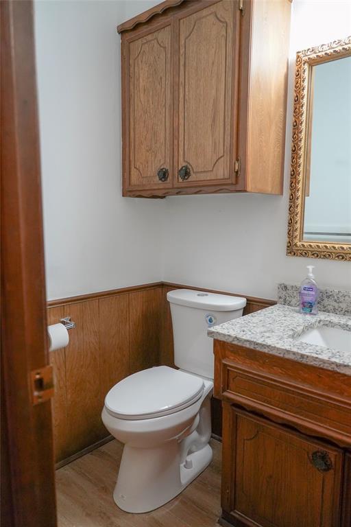 2313 SW 91st St, Oklahoma City, OK 73159 - half bathroom featuring vanity, toilet, and wood finished floors