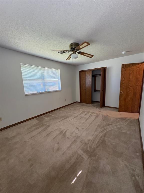 2313 SW 91st St, Oklahoma City, OK 73159 - unfurnished bedroom with a textured ceiling, a closet, baseboards, and a ceiling fan