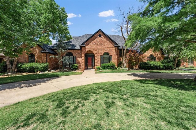 14705 Longford Way, Edmond, OK 73013 - view of front of house featuring brick siding, a front lawn, and a shingled roof