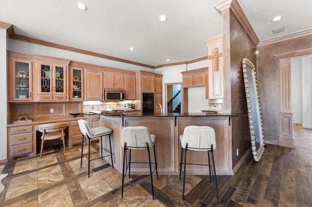 14705 Longford Way, Edmond, OK 73013 - kitchen with stainless steel microwave, a kitchen breakfast bar, oven, ornamental molding, and recessed lighting