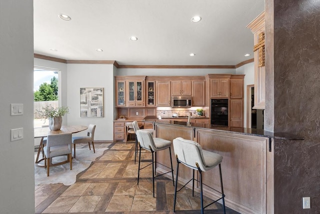 14705 Longford Way, Edmond, OK 73013 - kitchen featuring stainless steel microwave, ornamental molding, recessed lighting, a breakfast bar, and baseboards
