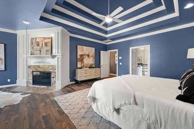 14705 Longford Way, Edmond, OK 73013 - bedroom with a raised ceiling, ornamental molding, wood finished floors, a fireplace, and a ceiling fan