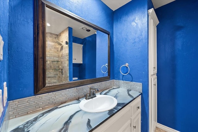 14705 Longford Way, Edmond, OK 73013 - full bath with vanity, decorative backsplash, a textured wall, and baseboards