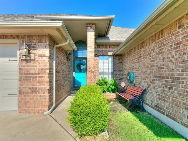 13005 Willowcrest Ln, Oklahoma City, OK 73170 - doorway to property with brick siding, a garage, and a shingled roof