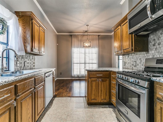 13005 Willowcrest Ln, Oklahoma City, OK 73170 - kitchen with stainless steel appliances, a sink, ornamental molding, decorative backsplash, and brown cabinets