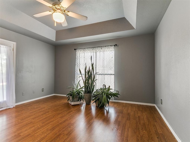 13005 Willowcrest Ln, Oklahoma City, OK 73170 - empty room featuring a tray ceiling, wood finished floors, baseboards, and ceiling fan