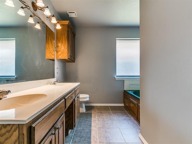 13005 Willowcrest Ln, Oklahoma City, OK 73170 - bathroom featuring baseboards, toilet, double vanity, a garden tub, and tile patterned flooring