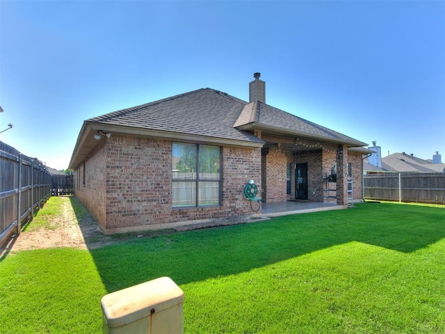 13005 Willowcrest Ln, Oklahoma City, OK 73170 - back of house featuring brick siding, a chimney, a patio area, and roof with shingles