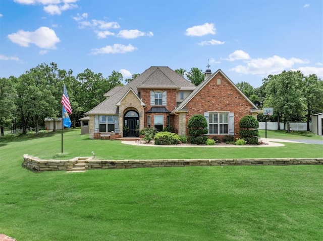 910744 S 3440th Rd, Chandler, OK 74834 - view of front of house featuring a front yard, brick siding, roof with shingles, and a chimney