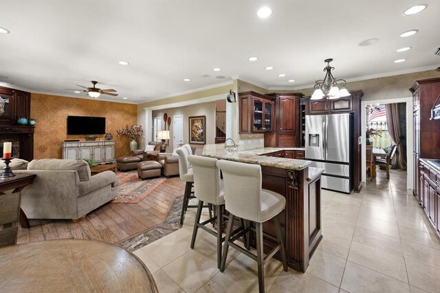 910744 S 3440th Rd, Chandler, OK 74834 - kitchen with stainless steel fridge, a peninsula, a breakfast bar, glass insert cabinets, and recessed lighting