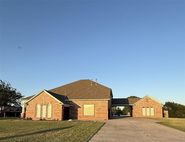 1030 Belmonte Ct, Yukon, OK 73099 - view of front of house featuring driveway, brick siding, a front yard, an attached carport, and a shingled roof