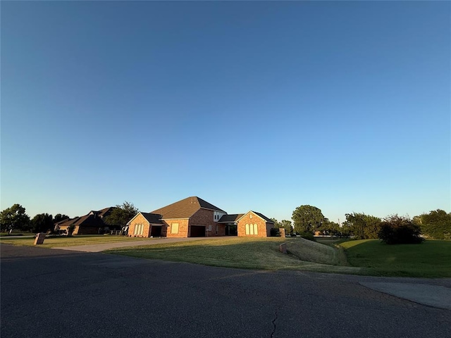 1030 Belmonte Ct, Yukon, OK 73099 - ranch-style home with driveway, stone siding, a front lawn, and an attached garage