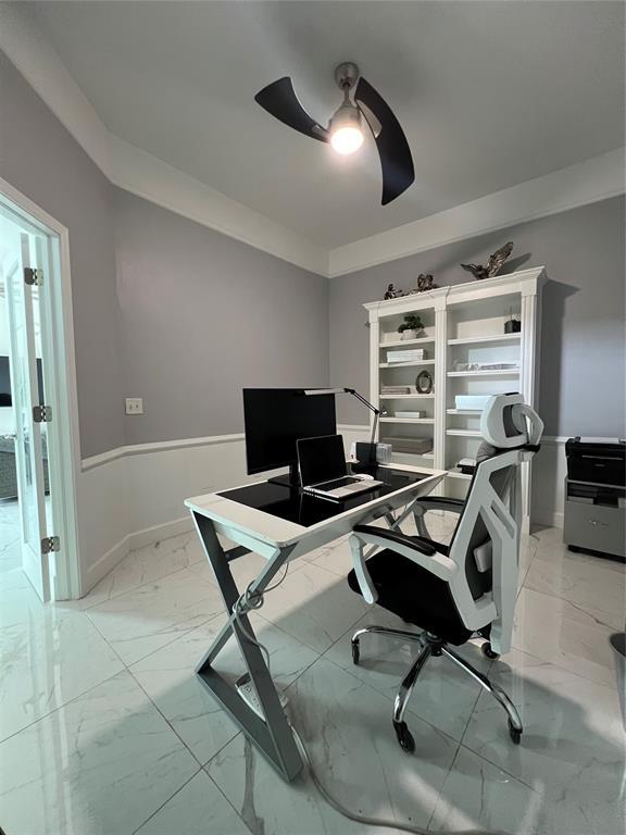 1030 Belmonte Ct, Yukon, OK 73099 - office area featuring light marble finish flooring, a ceiling fan, and baseboards