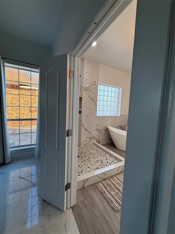 1030 Belmonte Ct, Yukon, OK 73099 - bathroom with a freestanding bath, marble finish floors, and a marble finish shower