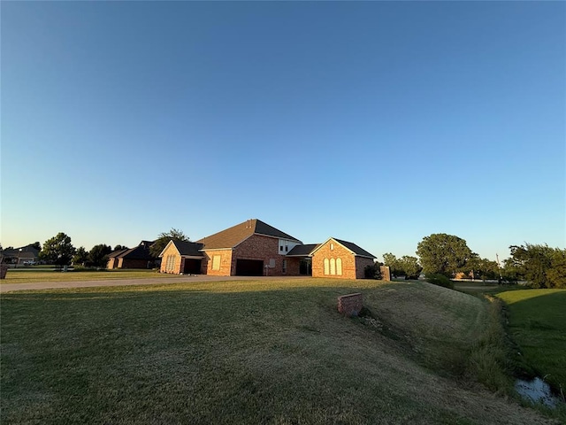 1030 Belmonte Ct, Yukon, OK 73099 - view of front of home featuring a front lawn, an attached garage, brick siding, driveway, and stone siding