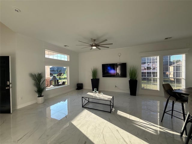 1030 Belmonte Ct, Yukon, OK 73099 - living room featuring marble tiled flooring, ceiling fan, and baseboards