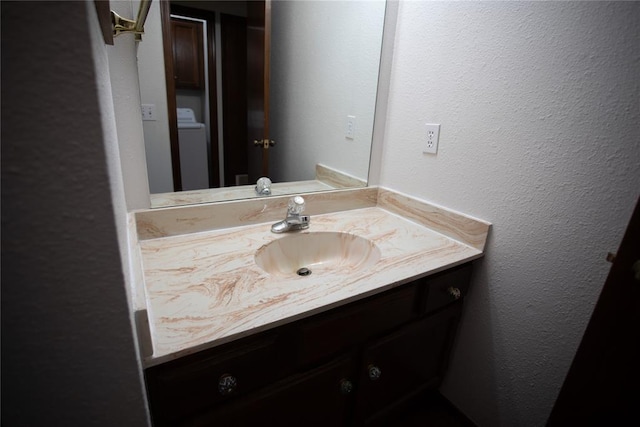 6414 Galaxie Ter, Oklahoma City, OK 73132 - bathroom featuring vanity, washer / clothes dryer, and a textured wall