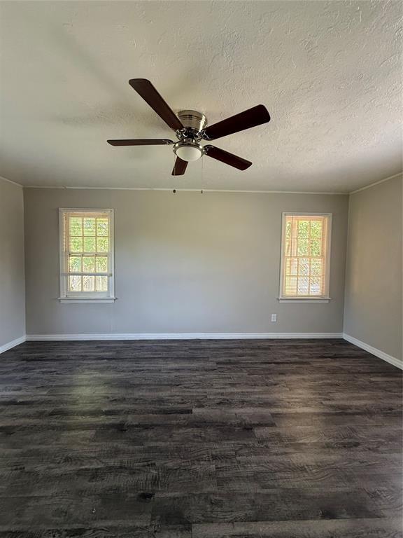 3208 N Roff Ave, Oklahoma City, OK 73112 - empty room featuring baseboards, dark wood finished floors, ceiling fan, and a textured ceiling