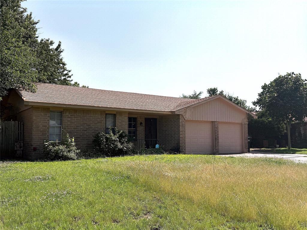 1044 NW 8th St, Moore, OK 73160 - ranch-style house featuring brick siding, a garage, and a front yard