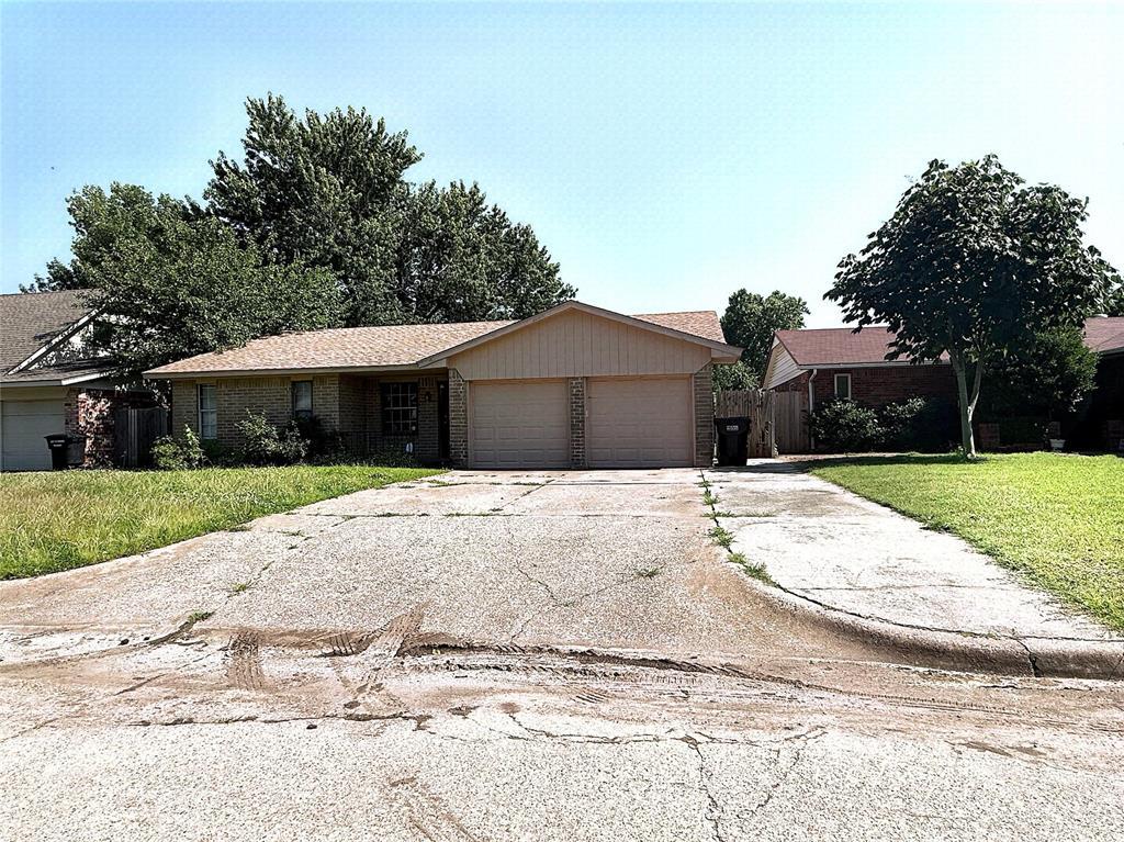 1044 NW 8th St, Moore, OK 73160 - ranch-style house with a garage, brick siding, and driveway