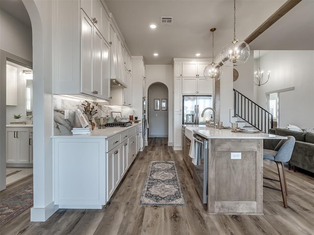 5617 NW 155th St, Edmond, OK 73013 - kitchen featuring arched walkways, stainless steel appliances, a breakfast bar, light countertops, and white cabinetry