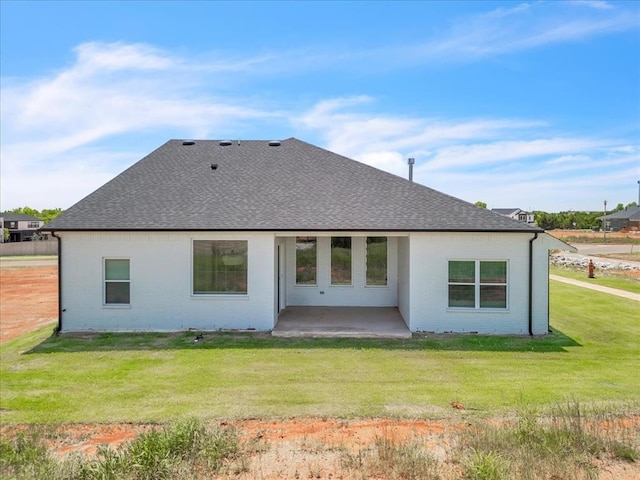 5617 NW 155th St, Edmond, OK 73013 - back of property featuring brick siding, a patio area, roof with shingles, and a yard