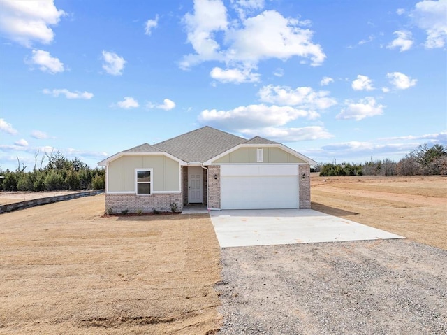 5201 Grassland Dr, Guthrie, OK 73044 - view of front of property with driveway, brick siding, board and batten siding, and a garage