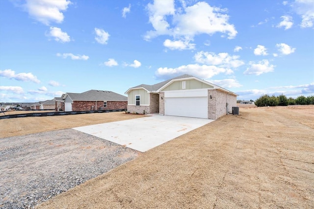 5201 Grassland Dr, Guthrie, OK 73044 - ranch-style house with driveway, brick siding, an attached garage, and central air condition unit