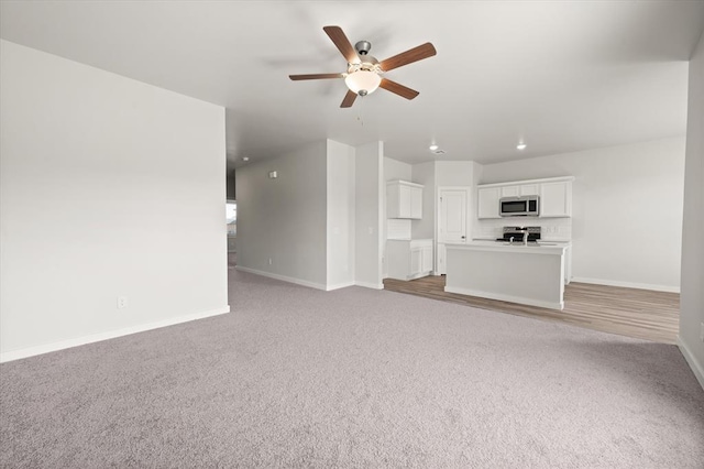 5201 Grassland Dr, Guthrie, OK 73044 - unfurnished living room with baseboards, ceiling fan, and light carpet