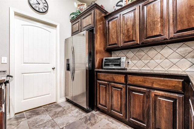 11444 NW 131st St, Piedmont, OK 73078 - kitchen with stainless steel refrigerator with ice dispenser, decorative backsplash, dark brown cabinetry, and dark stone counters
