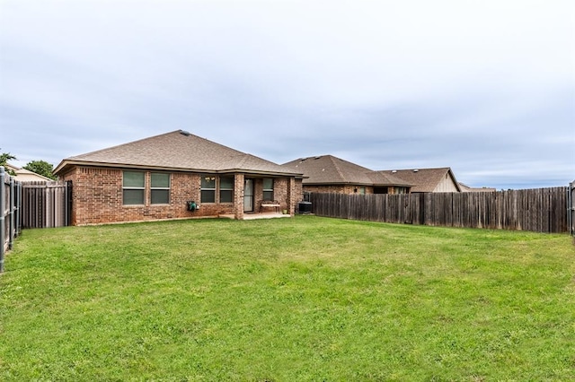 11444 NW 131st St, Piedmont, OK 73078 - rear view of property featuring brick siding, central AC, and a shingled roof