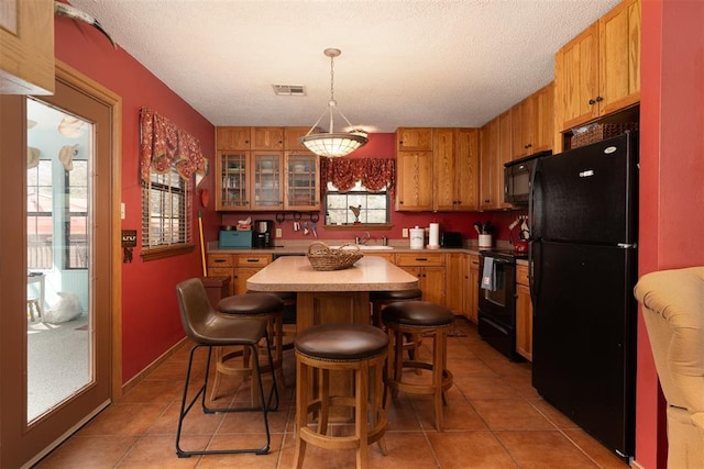 143 Robinson Ln, Ardmore, OK 73401 - kitchen featuring black appliances, light countertops, a sink, light tile patterned floors, and a textured ceiling