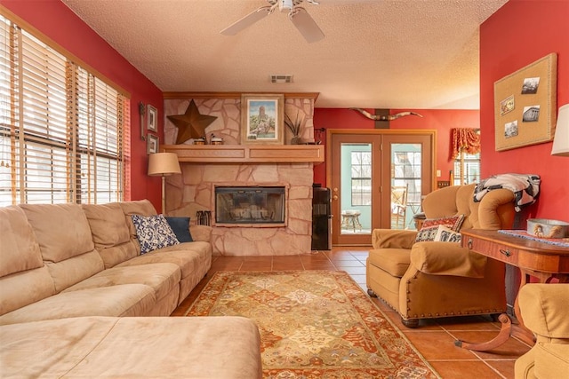 143 Robinson Ln, Ardmore, OK 73401 - tiled living area featuring a textured ceiling, ceiling fan, and a fireplace