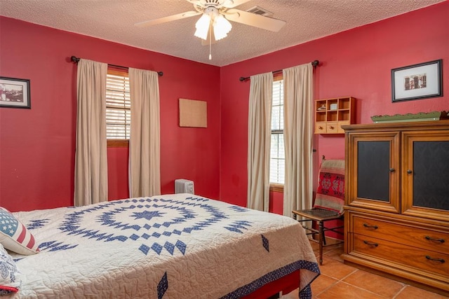 143 Robinson Ln, Ardmore, OK 73401 - bedroom featuring multiple windows, radiator, light tile patterned flooring, a textured ceiling, and a ceiling fan