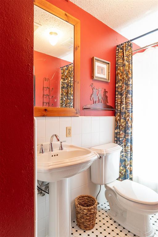 143 Robinson Ln, Ardmore, OK 73401 - bathroom with toilet, a textured ceiling, and a shower with curtain