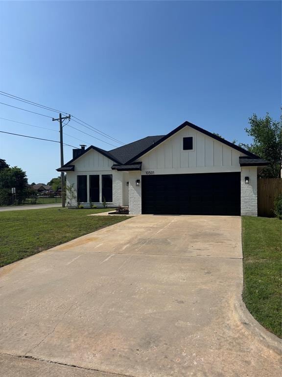 10501 Reiter Dr, Midwest City, OK 73130 - modern inspired farmhouse featuring board and batten siding, a garage, concrete driveway, a front lawn, and brick siding