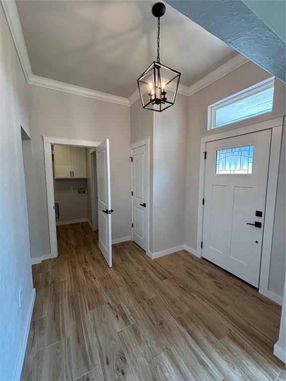 10501 Reiter Dr, Midwest City, OK 73130 - foyer entrance featuring a chandelier, crown molding, wood finished floors, and baseboards