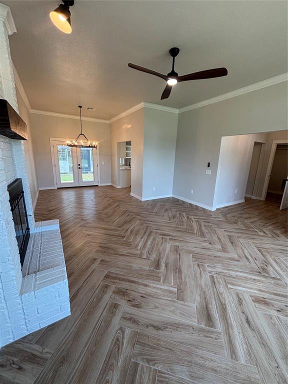 10501 Reiter Dr, Midwest City, OK 73130 - unfurnished living room with ceiling fan, a brick fireplace, baseboards, and ornamental molding