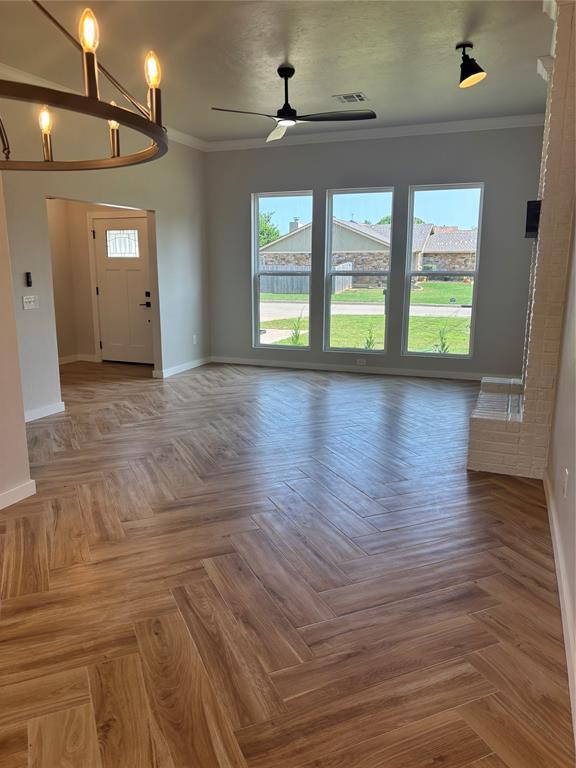 10501 Reiter Dr, Midwest City, OK 73130 - unfurnished living room with baseboards, ceiling fan, and ornamental molding