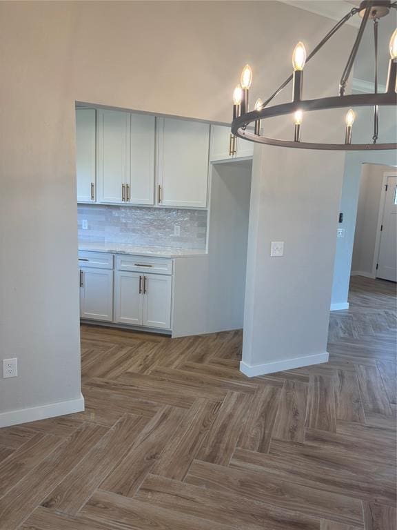 10501 Reiter Dr, Midwest City, OK 73130 - kitchen with baseboards, tasteful backsplash, a chandelier, and light countertops