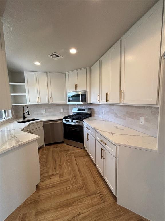 10501 Reiter Dr, Midwest City, OK 73130 - kitchen with appliances with stainless steel finishes, a sink, open shelves, white cabinetry, and recessed lighting